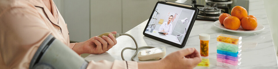 Web banner with woman measuring blood pressure when video calling general practitioner