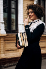 Beautiful girl in a vintage dress with books in her hands