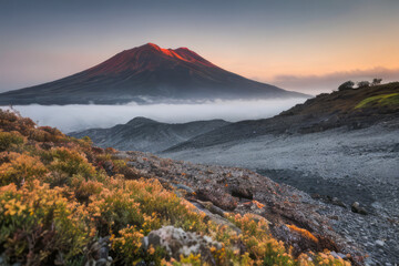 Fototapeta premium A majestic mountain landscape ablaze with autumn colors stretches towards a cloud-filled sky