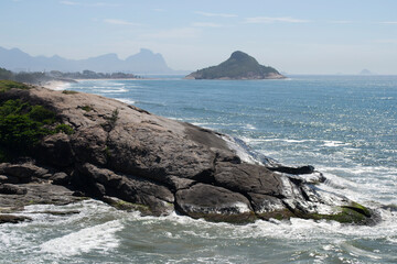 Panoramic view of the mountains, vegetation and the ocean with clear blue waters of Praia do Pontal, located in the city of Rio de Janeiro.