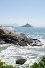 Panoramic view of the mountains, vegetation and the ocean with clear blue waters of Praia do Pontal, located in the city of Rio de Janeiro.