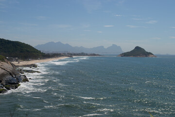 Panoramic view of the mountains, vegetation and the ocean with clear blue waters of Praia do Pontal, located in the city of Rio de Janeiro.