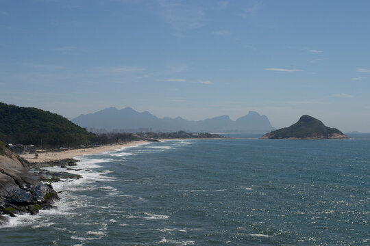 Panoramic view of the mountains, vegetation and the ocean with clear blue waters of Praia do Pontal, located in the city of Rio de Janeiro.