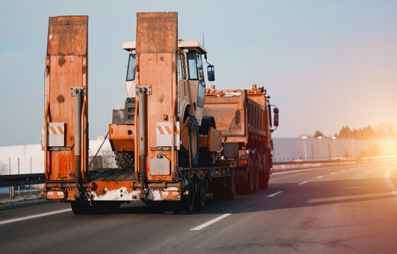 Towing Truck With A Agricultural Vehicle Farm Tractor On It. Emergency Roadside Assistance. Vehicle Mechanical Problem On The Road. Vehicle For Grain Farming. Bulldozer Evacuated.