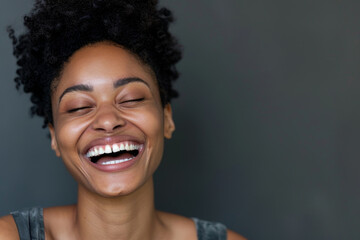 A woman with curly hair is smiling and laughing