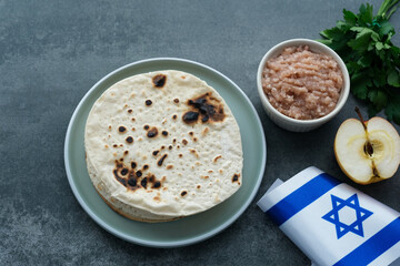 Handmade round Matzah in a plate on a concrete background. Saved Jewish Pesach Tradition. Jewish...