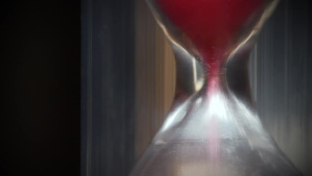 Red sand in hourglass. Time flows backwards, in opposite direction. Time cures all things. Time is the great healer. Time works wonders. 4K 60fps macro shot reverse time video