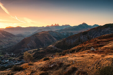 French Alps landscape of sunrise shining over Arves massif and ski town in valley during autumn at...