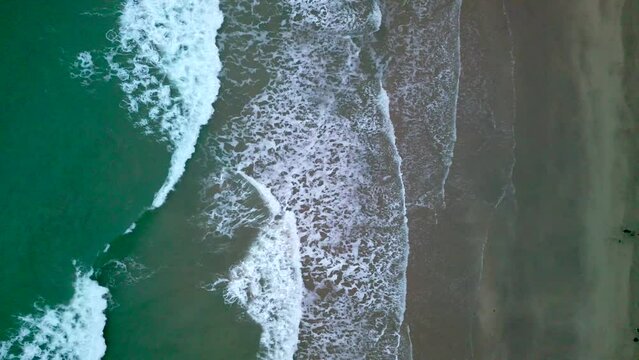 Waves crashing down on a beach (Portrush West Strand). Camera begins overhead and pushes closer to the sand.

Filmed at 4K 60 frames per second and in Rec709 color space.