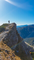 Naklejka na ściany i meble Hiker man standing on mountain summit with panoramic view of majestic Hochschwab massif, Styria, Austria. Idyllic hiking trail in remote Austrian Alps. Sense of escapism, peace, personal reflection