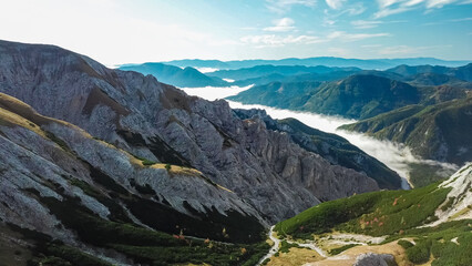 Obraz premium Scenic view of fog covered valley in Hochschwab mountain range, Styria, Austria. Hiking trail in alpine forest. Remote Austrian Alps in summer. Escapism. Connect with nature