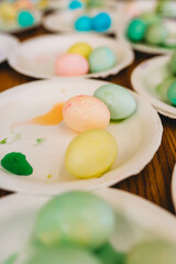 Colorful dyed Easter eggs on white paper plates