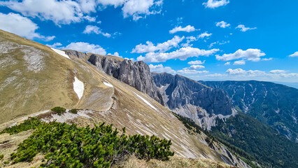 Idyllic hiking trail along golden alpine meadow with panoramic view of majestic Hochschwab massif,...