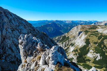 Panoramic view from mountain summit Foelzstein in wild Hochschwab massif, Styria, Austria. Looking at majestic Ennstaler Alps in Gesaeuse national park in distance. Wanderlust in remote Austrian Alps