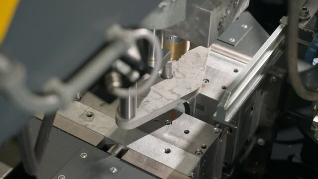 Industrial machine mechanism shaping the white bottles on a production line. Industrial mechanism forming the plastic bottles. Industrial equipment mechanism moulding the bottles at the plant.