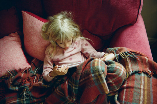 A girl with a tablet on the sofa