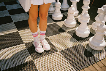 Woman standing on the square of giant  chess board 