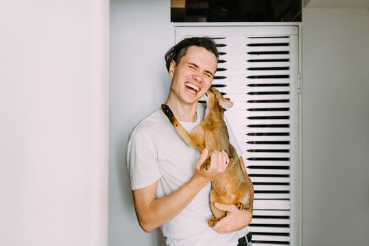 Young laughing man holding abyssinian cat