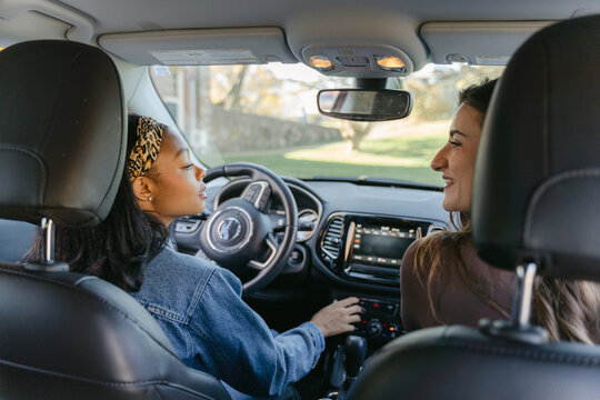 happy young woman and her friend in car 