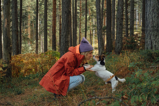 Young Woman and Her Dog Cuddling in The Forest 