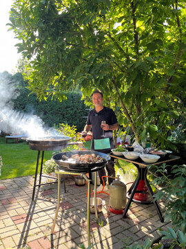 Man Cooking Two Paella in The Big Outdoor Pan