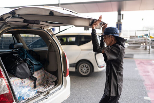 Male driver opening the car trunk.