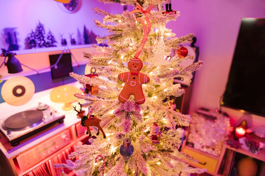 A gingerbread man hanging from the t Christmas tree