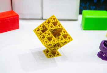 Abstract yellow object printed on 3D printer. Abstract geometric shaped object created by 3D printer. Detailed prototype printed on 3D printer close-up. New modern additive 3D printing technologies