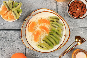 Healthy breakfast with ingredients, Rice pudding with kiwi, honey, tangerines and almonds.flat lay, Healthy and natural food concept, lifestyle, food for children