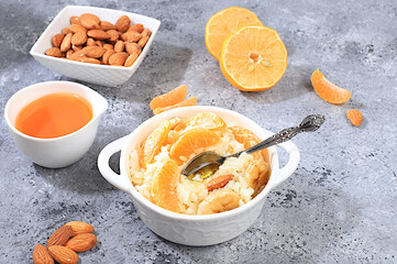 Rice pudding with bananas, honey, tangerines and almonds. Healthy breakfast with ingredients, flat lay, Healthy and natural food concept, lifestyle, food for children,
