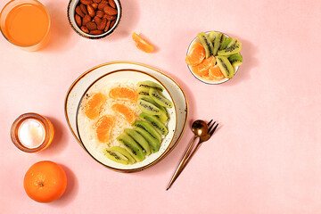 Rice pudding with kiwi, honey, tangerines and almonds. Healthy breakfast with ingredients, flat lay, Healthy and natural food concept, lifestyle, food for children,