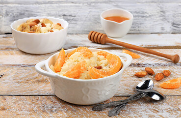 Rice pudding with bananas, honey, tangerines and almonds. Healthy breakfast with ingredients, flat lay, Healthy and natural food concept, lifestyle, food for children