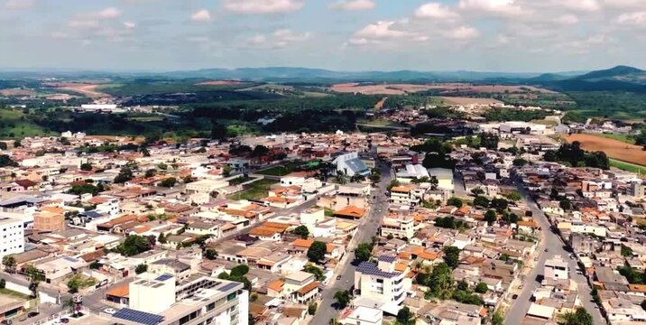 aerial video of a densely populated city with little agricultural land on the outskirts of the city