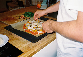 Anonymous man cooking vegetable pizza 