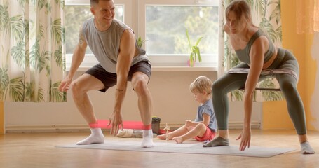 Couple is engaging in home workouts together, participating in joint exercises jumping or cardio movements. Couple sets positive example for their family, promoting an active lifestyle from young age.