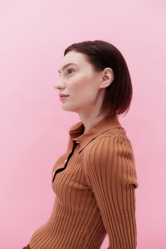 Profile portrait young woman pink background