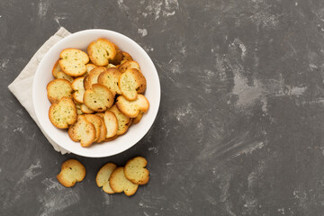 Spiced bruschette chips on concrete background, top view