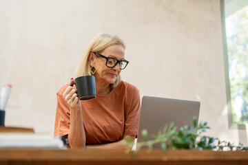 mature woman working at home studio in a home decor project 