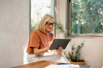 mature woman working at home studio in a home decor project 