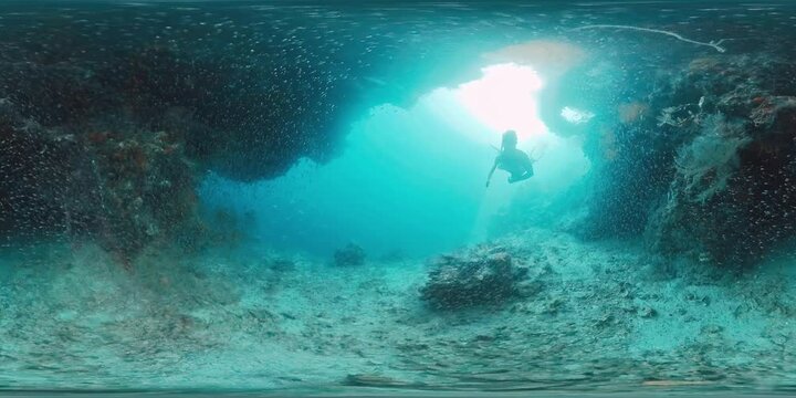 360 vr footage of the freediver swimming underwater in the tropical sea and exploring intricate seascape and abundant marine life of the West Papua region in Indonesia