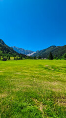 Lush green alpine meadow of Maerchenwiese with panoramic view of Karawanks mountains in Carinthia,...