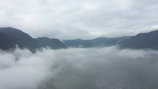 Aerial footage of mist-surrouded mountains in the early morning