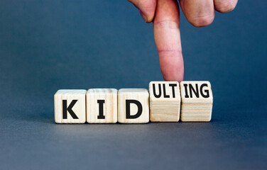 Kid or kidulting symbol. Concept words Kid or Kidulting on wooden cubes. Beautiful grey table grey...