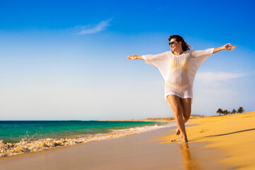 Beautiful woman walking on sunny beach
