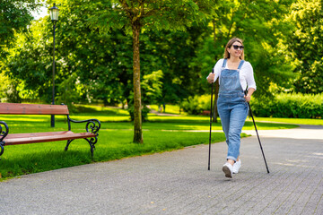 Nordic walking - woman exercising in city park
