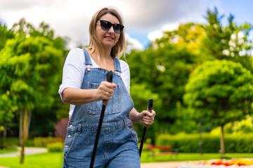 Nordic walking - woman exercising in city park
