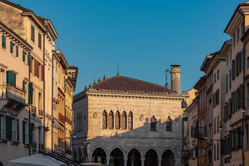 Stroll along narrow urban street at sunrise that meanders towards magnificent ancient city center of charming town Udine, Friuli Venezia Giulia, Italy, Europe. Urban tourism in northern Italian city