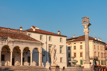 Statue of San Marco lion on top of column and Hercules in front of Loggia del Lionello on main...