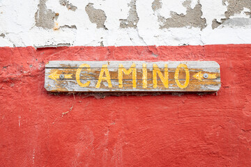 Camino written on a wooden board indicating the right direction to the way