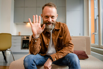 A man is talking on a video call looking at camera